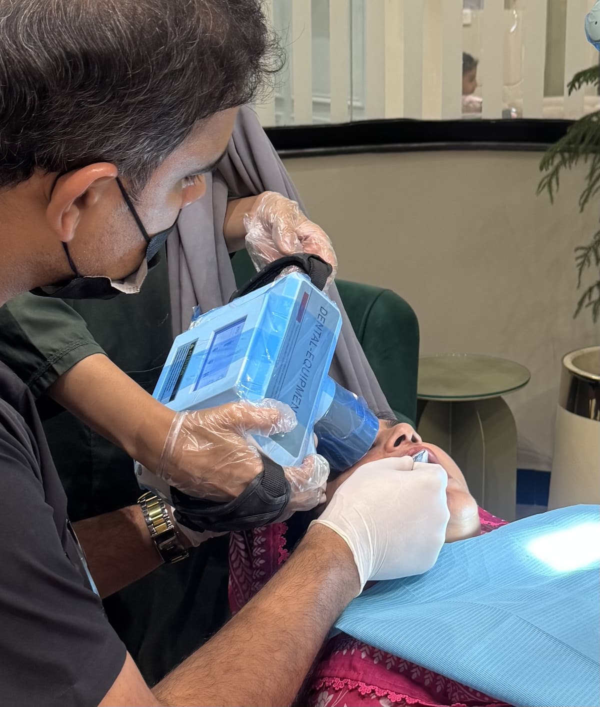 Handheld digital dental X-ray imaging in use during a patient exam
